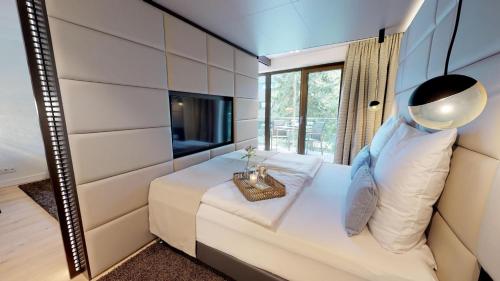 ein Schlafzimmer mit einem großen Bett und einem Spiegel in der Unterkunft White Pearl Apartment 1.05 in Timmendorfer Strand