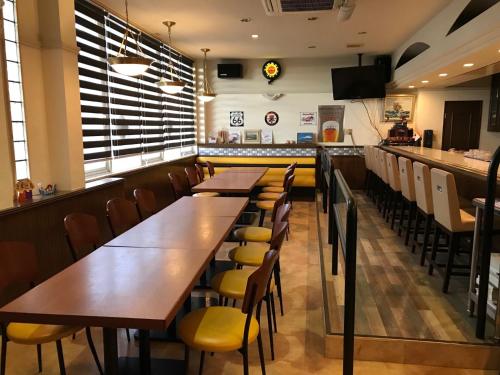 a dining room with wooden tables and yellow chairs at Tabist Miya Yokkaichi Suizawa in Suizawa