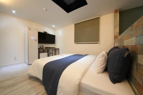 a bedroom with a large bed and a television at 2Night Business Hotel in Jeonju