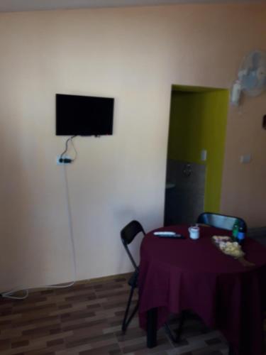 Habitación con mesa y TV en la pared. en Santorini Bed en Córdoba en Córdoba