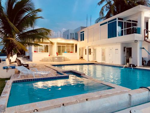 una gran piscina frente a una casa en Ventana al Atlantico at Arecibo 681 Ocean Drive en Arecibo
