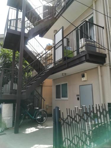 a bike parked in front of a building with a staircase at 駅近-JR小岩駅まで徒歩3分-Leo小岩 101 in Tokyo