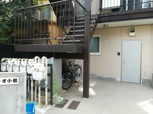 un vélo garé à côté d'un bâtiment avec un escalier dans l'établissement 駅近-JR小岩駅まで徒歩3分-Leo小岩 101, à Tokyo