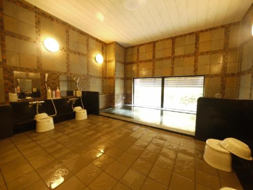 a large room with a bathroom with a large window at Hotel Route-Inn Suwa-Inter2 in Suwa