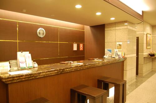 a hotel lobby with a counter and two stools at Hotel Route-Inn Nagahama Inter in Nagahama