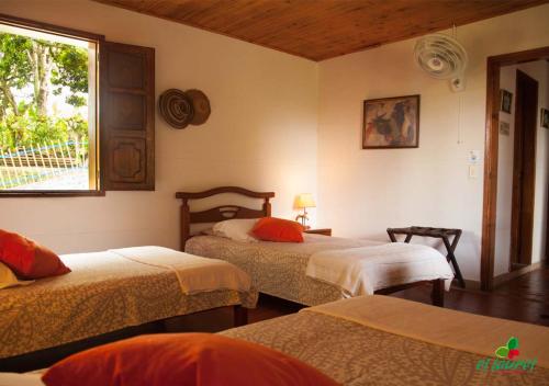 a bedroom with two beds and a window at El Laurel Finca Agroturistica in Quimbaya