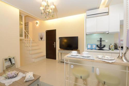 a living room with a television and a staircase at BV Taipei XinYi D in Taipei