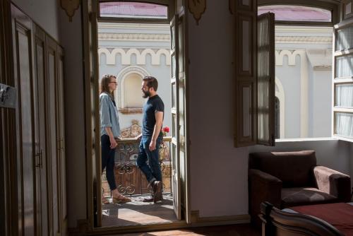 two men standing in a room looking in a mirror at Hotel La Orquidea in Cuenca
