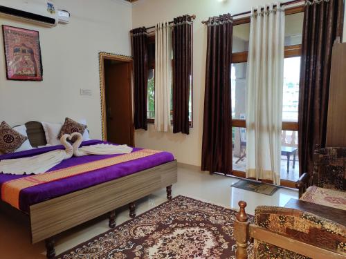Un dormitorio con una cama con sábanas y ventanas púrpuras. en Hotel Tiger Haveli en Sawāi Mādhopur