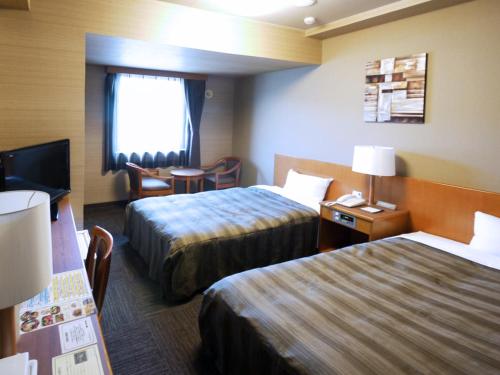 Postel nebo postele na pokoji v ubytování Hotel Route-Inn Suwa Inter