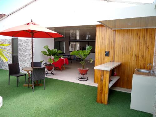 a patio with a table and chairs and an umbrella at Hotel Nova Park in Arauca
