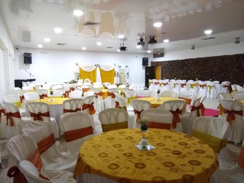 a banquet hall with yellow and white tables and chairs at Hotel Nova Park in Arauca