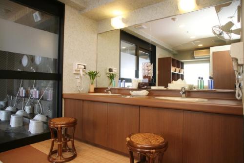 a bathroom with a counter with two stools and a mirror at Hotel Route-Inn Tokuyama Ekimae in Shunan