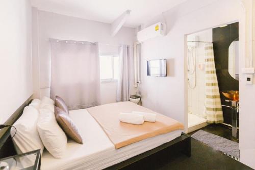 ein weißes Zimmer mit einem Bett mit zwei Kissen in der Unterkunft 3Howw Hostel Khaosan in Bangkok