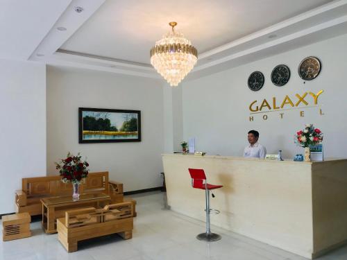 Ein Mann, der am Tresen eines Salons steht. in der Unterkunft Galaxy Hotel in Quy Nhon