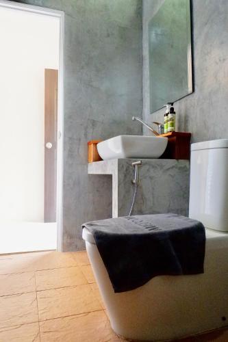 a bathroom with a sink and a toilet with a mirror at Aiya Resort Koh-Tao in Ko Tao