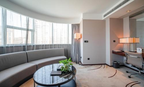a living room with a couch and a table at Ramada Changzhou North Hotel in Changzhou