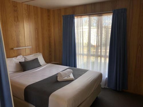 a bedroom with a large bed with a window at Discovery Parks - Hadspen in Hadspen