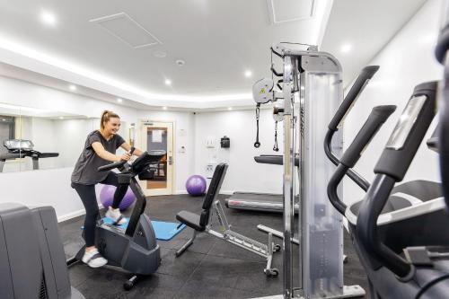 a woman exercising on a treadmill in a gym at ibis Styles Kingsgate Hotel in Melbourne