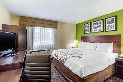 a hotel room with a bed and a desk and a television at Sleep Inn Ogden near Event Center in Ogden