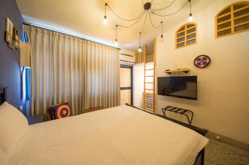 a room with a bed and a table and a window at 台東市區 童年時光六人包棟民宿 附廚房及電動麻將 in Taitung City