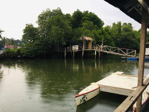 a boat is docked at a dock on a river at Homestay Cikgu Sungai Batu Besi in Bedung