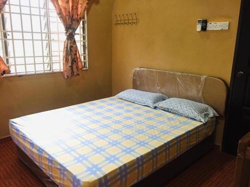 1 dormitorio con 1 cama con edredón azul y blanco en Homestay Cikgu Sungai Batu Besi, en Bedung