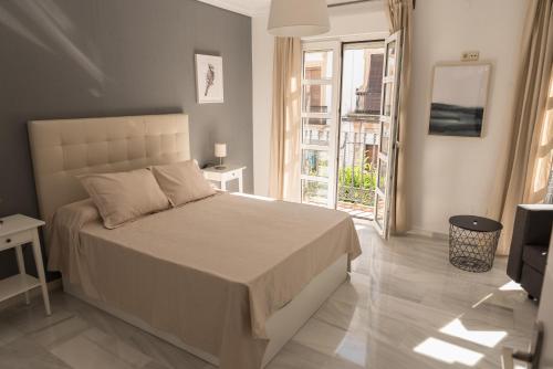 a bedroom with a bed and a large window at Apartamento Centro La Paz by CasaTuristica in Ronda