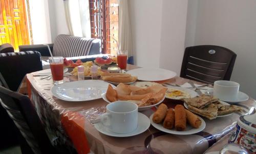 a table with plates of food on top of it at Lavendra Guset House in Adams Peak