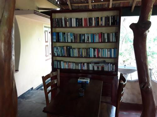 uma estante cheia de livros em Suduweli Beauties of Nature - Yala em Kirinda