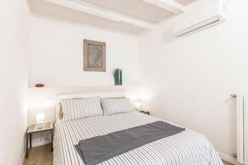 ボローニャにあるSweet Home Bologna 3の白いベッドルーム(ストライプシーツ付きのベッド1台付)