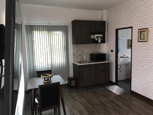 a kitchen with a table and chairs and a kitchen with a counter at SB Holiday Resort Chiang Mai in Chiang Mai