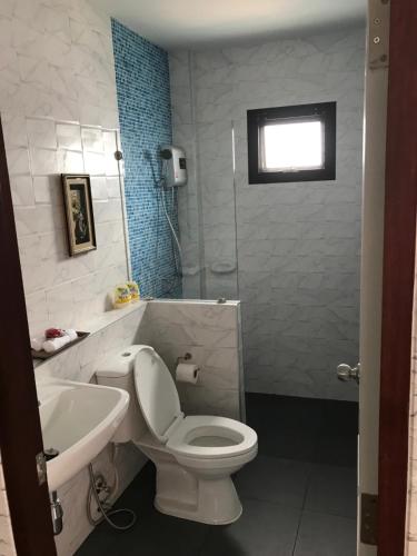 ein Badezimmer mit einer weißen Toilette und einem Waschbecken in der Unterkunft SB Holiday Resort Chiang Mai in Chiang Mai