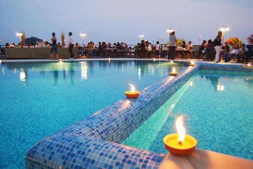 a swimming pool with lit candles in the water at Residence Sole in Albenga