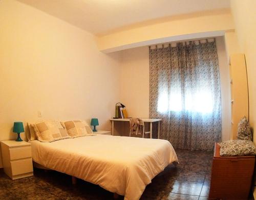 Un dormitorio con una cama grande y una ventana en Benimaclet, en Valencia