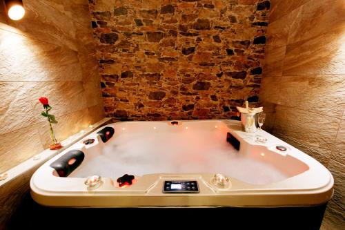eine Badewanne in einem Zimmer mit Ziegelwand in der Unterkunft Hotel Otakar in Prag