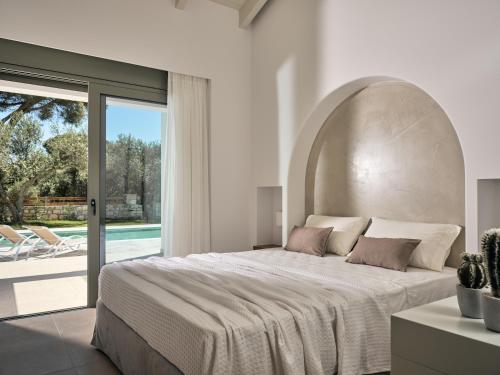 una camera con un grande letto e una grande finestra di Gerakas Luxury Villas a Vasilikós