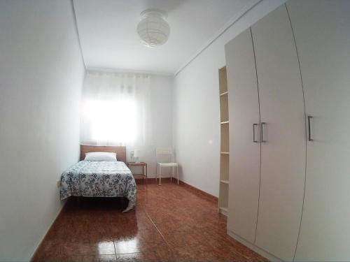 um quarto com uma cama e um armário branco em MALVARROSA em Valência