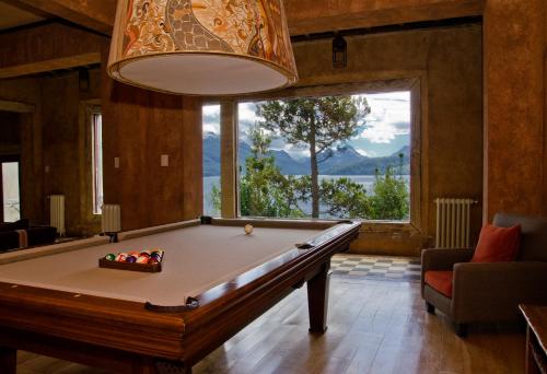 a pool table in a room with a large window at Luma Casa De Montaña in Villa La Angostura