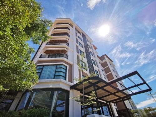 a tall building with the sun in the sky at S Park Design Hotel in Vientiane
