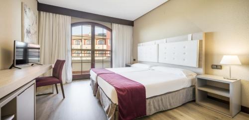 Una habitación de hotel con una cama grande y una ventana. en Ilunion Golf Badajoz, en Badajoz