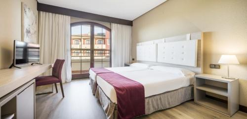 a hotel room with a large bed and a window at Ilunion Golf Badajoz in Badajoz