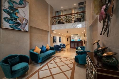 a lobby with blue chairs and a staircase at Hanoi Fiesta Central Hotel and Spa in Hanoi