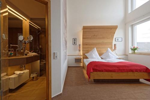 a bedroom with a bed and a sink and a mirror at Hotel zur Malzmühle in Cologne