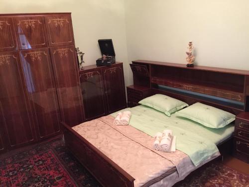 a bedroom with a bed with two pink shoes on it at Munis in Samarkand