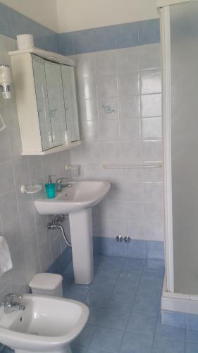 a bathroom with a sink and a toilet and a shower at Hotel La Bussola in Muggia