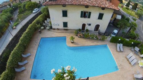 vista sul tetto di una piscina di fronte a una casa di Hotel Alberello a Riva del Garda