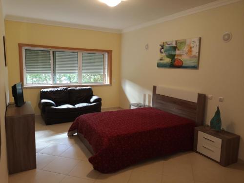 - une chambre avec un lit et un canapé dans l'établissement Espirito Santo Apartment, à Portimão
