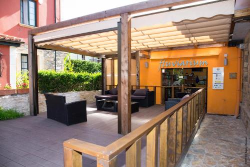 a pergola with chairs and tables on a patio at Hostal Lierganes Fluviarium Rooms in Liérganes