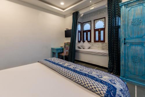 a bedroom with a bed with a blue cabinet at Hotel Mewari Villa PURE VEG in Udaipur
